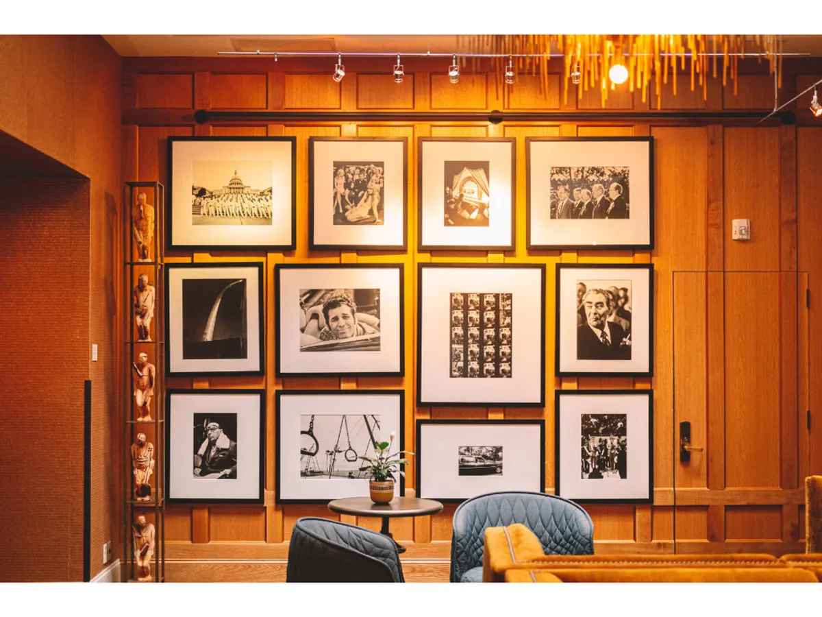 A modern lounge area with a gallery wall of framed photographs and decorative sculptures, paired with contemporary furniture. The space encourages socializing, relaxing with a book, or sparking conversations inspired by the art on display.